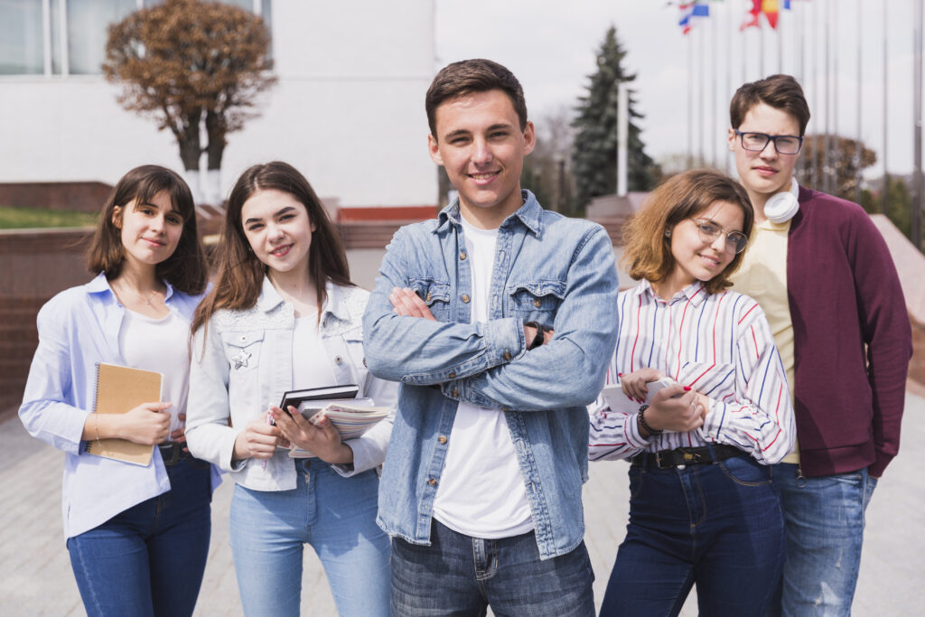 man-surrounded-by-smart-students-with-books-looking-camera