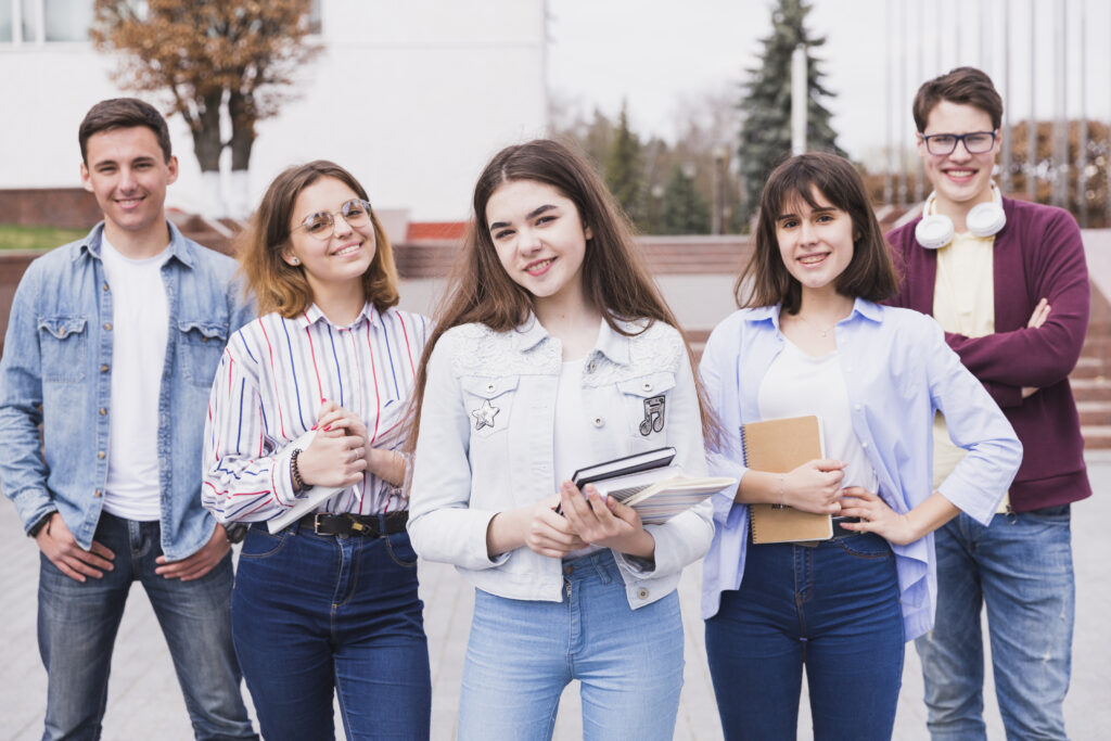 men-women-standing-with-books-looking-camera